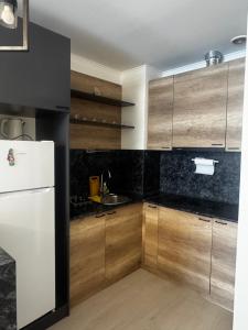 a kitchen with wooden cabinets and a white refrigerator at Alvina Complex in Tsaghkadzor