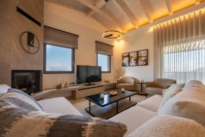 ein Wohnzimmer mit Sofa und Fernseher in der Unterkunft Vivere Suites in Nafplio