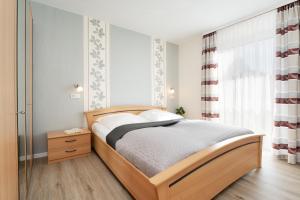 a bedroom with a wooden bed and a window at Haus Tweeflunken Wohnung 1 in Kellenhusen