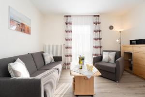 a living room with a couch and a table at Haus Tweeflunken Wohnung 1 in Kellenhusen