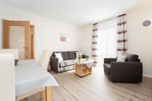 a living room with two chairs and a couch at Haus Tweeflunken Wohnung 1 in Kellenhusen
