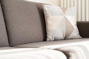 a gray couch with a pillow on it at Haus Tweeflunken Wohnung 1 in Kellenhusen