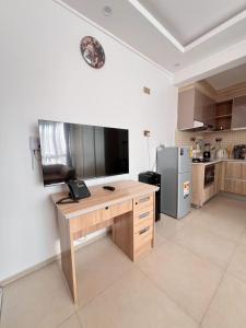 a kitchen with a wooden desk and a refrigerator at Sharz Cozy studio - Westlands in Nairobi