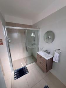 a white bathroom with a shower and a sink at Sharz Cozy studio - Westlands in Nairobi
