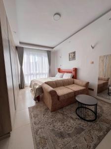 a bedroom with a large bed and a table in it at Sharz Cozy studio - Westlands in Nairobi