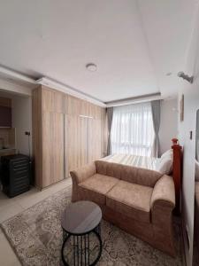 a living room with a couch and a bed at Sharz Cozy studio - Westlands in Nairobi