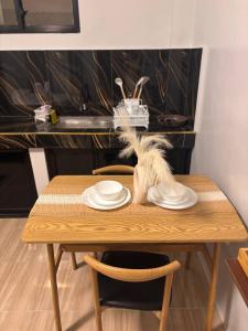 a wooden table with two white plates on it at Perrera Guesthouse in Santa Ana