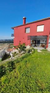 a red house on top of a grassy hill at Casaemy in Pineda de Mar