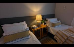 a bedroom with two beds and a table with a lamp at Ocean View Nature Lodge in St Lucia