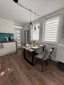 a dining room with a table and chairs in a kitchen at H&H Apartman in Fonyód