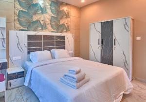 a bedroom with a bed with towels on it at Hill Breeze Pool Resort Vagamon by VOYE HOMES in Vagamon