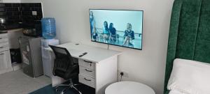 a room with a desk and a tv on a wall at Starla, Duplex in Nairobi