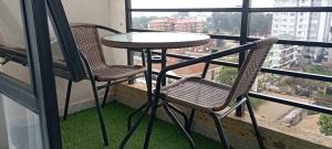 a table and two chairs on a balcony at Starla, Duplex in Nairobi