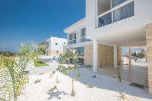 a large white building with a patio in front of it at Vie Bleu Villas in Protaras