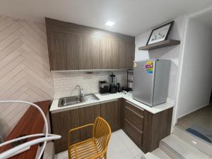 a small kitchen with a sink and a refrigerator at Moonrise Beachfront Luxury in Nathon Bay +3 photos