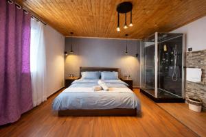 a bedroom with a large bed and a wooden ceiling at GuestHouse Mendrika in Talata-maty