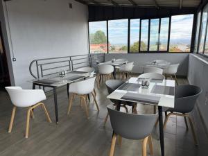 a restaurant with tables and chairs and windows at GuestHouse Mendrika in Talata-maty