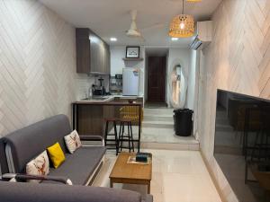 a living room with a couch and a kitchen at Moonrise Beachfront Luxury in Nathon Bay