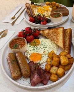 a plate of breakfast food with eggs sausage and toast at Oluhle Resort in Hammanskraal