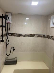 a bathroom with a bath tub with a shower at Moonrise Beachfront Luxury in Nathon Bay