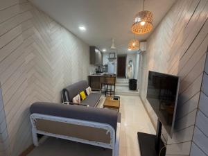 a living room with a couch and a tv at Moonrise Beachfront Luxury in Nathon Bay