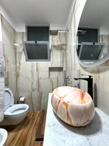 a bathroom with a large sink and a toilet at Beach Apartments Durres in Durrës +54 photos