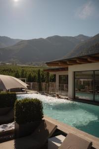 a house with a swimming pool with mountains in the background at Das Paradies in Laces