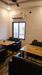 a room with tables and chairs and a window at Hotel Jatra in Sillod