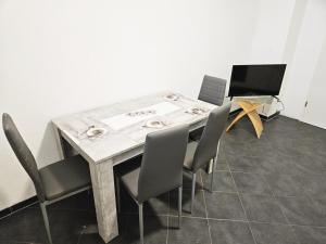 a dining room table with chairs and a laptop at AC01-AC06 Apartment in Herzogenrath in Herzogenrath
