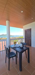 a black table and chairs in a room with a balcony at Calamianes Homestay in Coron