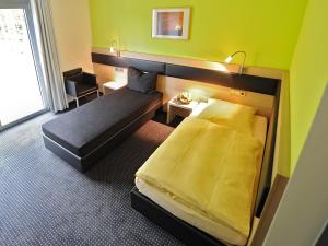 a hotel room with a bed and a window at Hotel und Kongresszentrum Wanderath in Baar