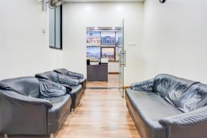 a row of leather couches in a room at Super Collection O Pashan-Sus Road Baner Formerly Grey Stone in Pune +33 photos