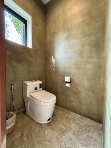 a bathroom with a toilet and a window at Private Bungalow, Large Salt Water Pool & Jacuzzi, Super Fast WIFI 100Mbps in Phumĭ Kruŏs