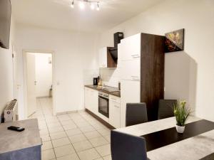 a kitchen with white cabinets and a table in it at AC01-AC06 Apartment in Herzogenrath in Herzogenrath +31 photos