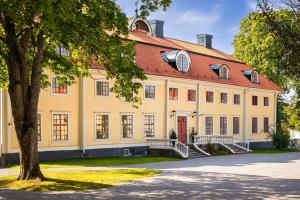 a large white building with a red roof at Söderfors Herrgård in Söderfors