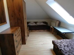 a attic room with a bed and a wooden floor at Zofijówka in Osjaków