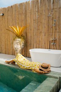 a person laying on the edge of a pool next to a bath tub at Lime Splash Private pool in Choeng Mon Beach