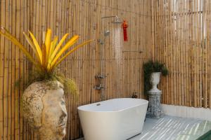 a bathroom with a bath tub and a plant at Lime Splash Private pool in Choeng Mon Beach