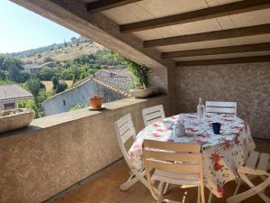 a table and chairs on a balcony with a view at La marelle in Villerouge-Termenès