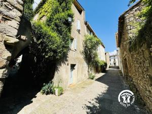 an alley with ivy on the side of a building at La marelle in Villerouge-Termenès +15 photos