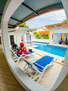two people sitting in chairs next to a swimming pool at CLASSIC BNBs MILIMANI in Kisumu