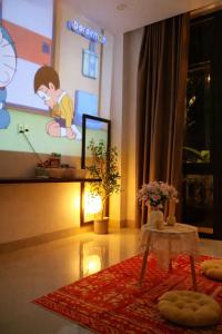 a room with a tv and a table and a screen at Pavillon D'Hue Homestay in Hue