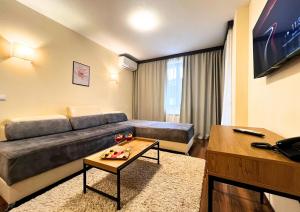 a living room with a couch and a table at St George Ski & Holiday - Half Board & All Inclusive in Bansko