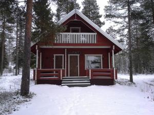 a red cabin in the woods in the snow at Vipati Cottage in Ylitornio