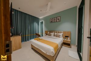 ein Schlafzimmer mit einem großen Bett in einem Zimmer in der Unterkunft THE M HOTEL in Raipur