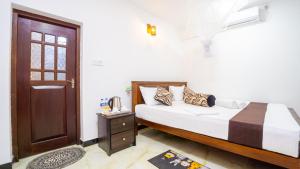 a bedroom with a bed and a door and a table at Villa Swallow Nest in Sigiriya