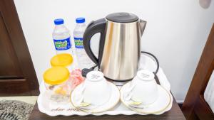 a tray with a coffee pot and bottles of water at Villa Swallow Nest in Sigiriya