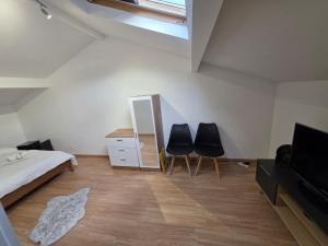 a bedroom with two black chairs and a mirror at Maison de ville entièrement équipée in Argenteuil