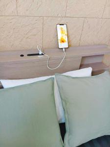 a bed with two pillows and a clock on a wall at ゲストハウス瓦町 in Takamatsu
