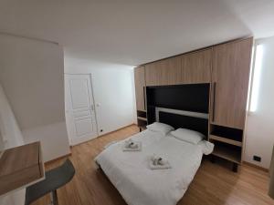 a bedroom with a bed with two towels on it at Maison de ville entièrement équipée in Argenteuil